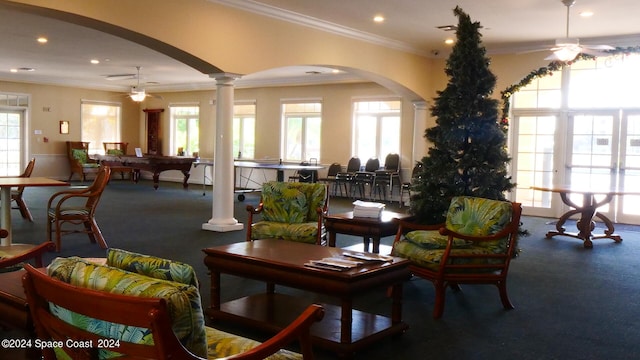 living room featuring ceiling fan, crown molding, and ornate columns