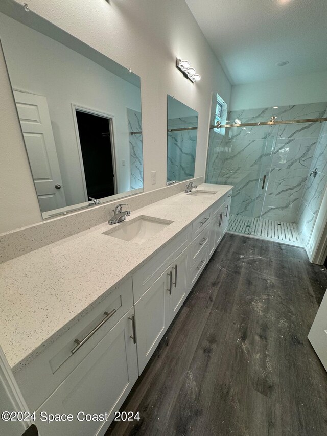 bathroom with hardwood / wood-style floors, a shower with door, a textured ceiling, and vanity