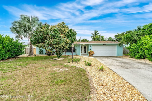 single story home with a garage and a front lawn