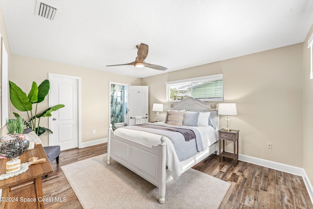 bedroom with dark hardwood / wood-style flooring, ceiling fan, and connected bathroom