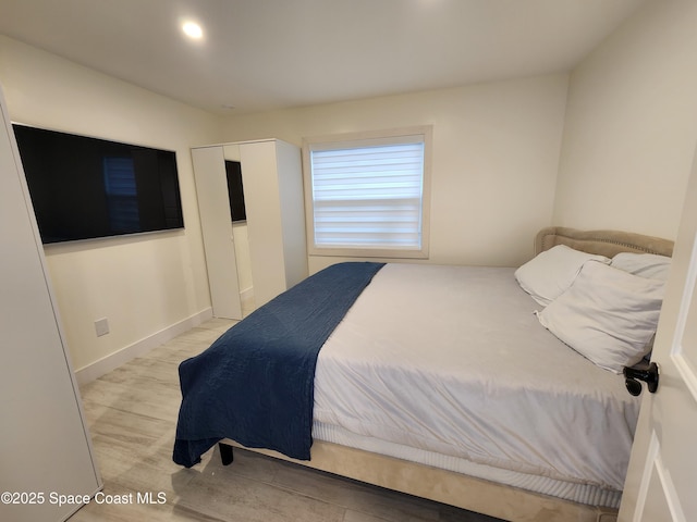 bedroom with recessed lighting, light wood-type flooring, and baseboards