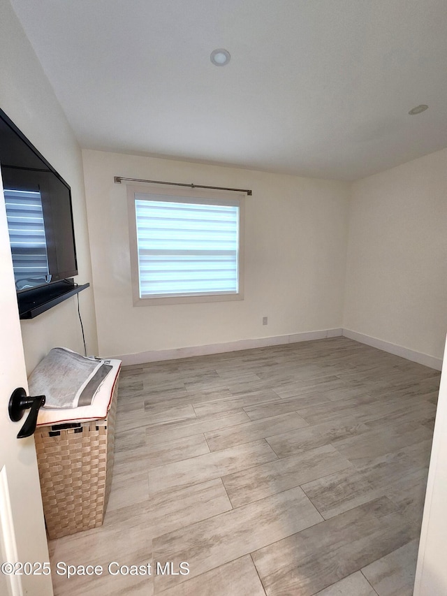 empty room with baseboards and wood finished floors