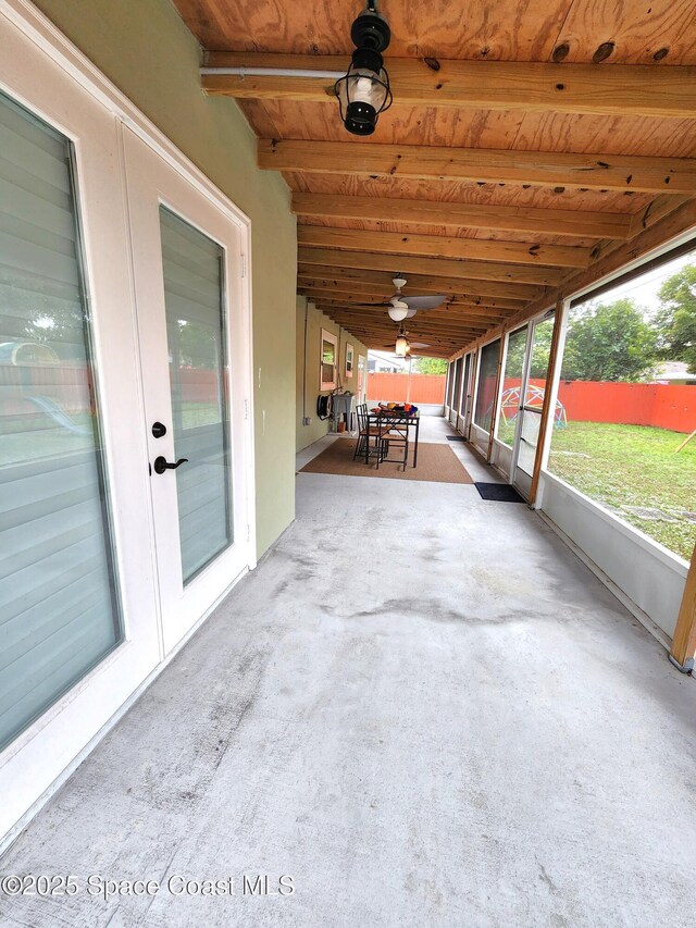 unfurnished sunroom featuring wood ceiling and beamed ceiling