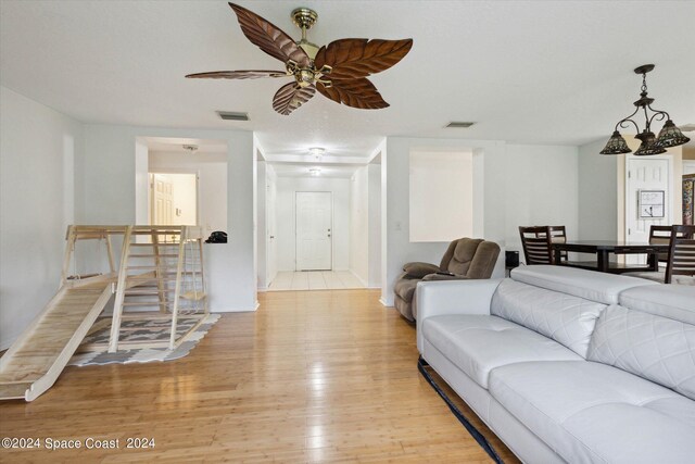 living room featuring ceiling fan and light hardwood / wood-style floors