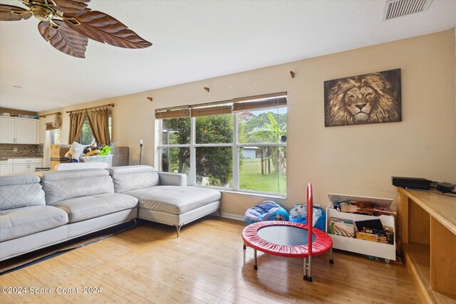 living room with light wood-type flooring and ceiling fan