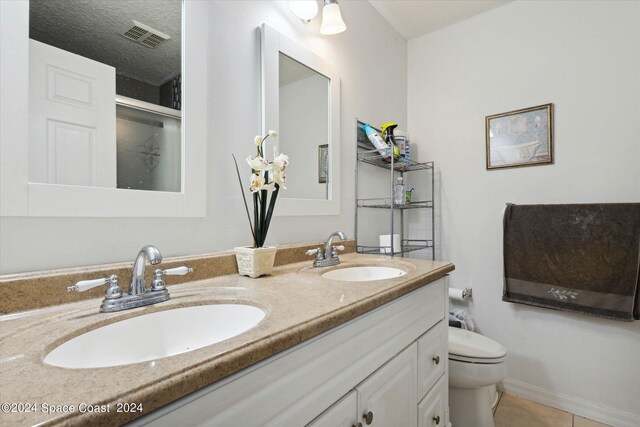 bathroom with toilet, an enclosed shower, tile patterned flooring, vanity, and a textured ceiling