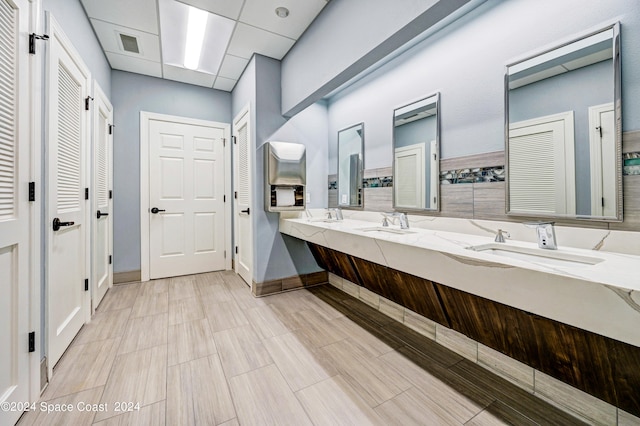 bathroom featuring vanity and a drop ceiling