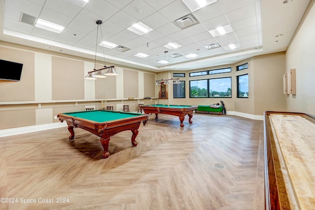 game room featuring parquet flooring, a drop ceiling, and a tray ceiling