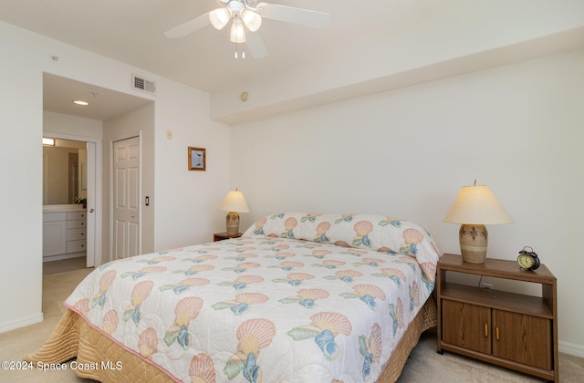 carpeted bedroom with a closet, ceiling fan, and ensuite bathroom