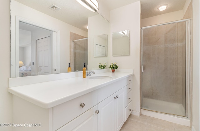 bathroom featuring vanity, walk in shower, and tile patterned flooring