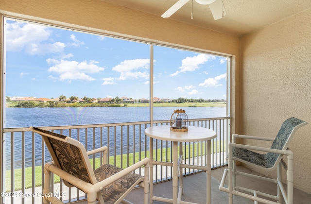 sunroom with a water view and ceiling fan