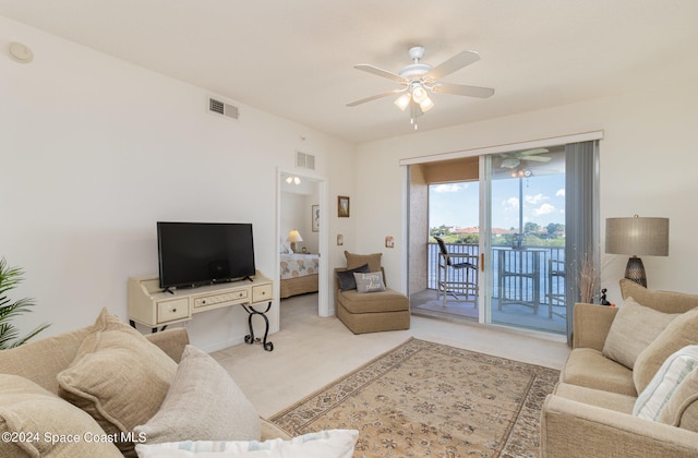 carpeted living room with ceiling fan