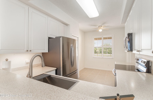 kitchen with ceiling fan, stainless steel appliances, sink, and white cabinets