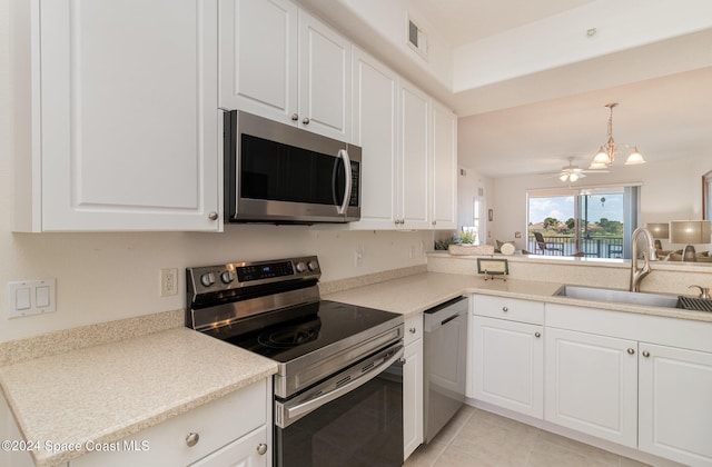 kitchen with light tile patterned floors, appliances with stainless steel finishes, sink, and white cabinets