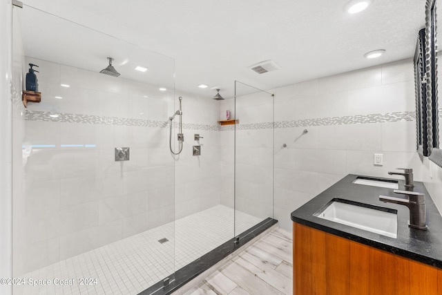 bathroom with vanity, hardwood / wood-style flooring, and tiled shower