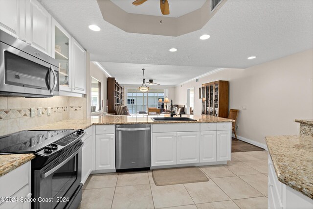 kitchen featuring ceiling fan, sink, appliances with stainless steel finishes, and kitchen peninsula