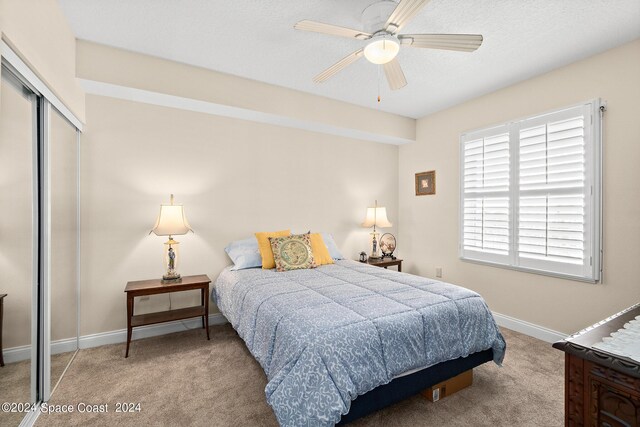 bedroom featuring a closet, ceiling fan, and light carpet