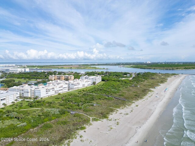 drone / aerial view featuring a water view and a view of the beach