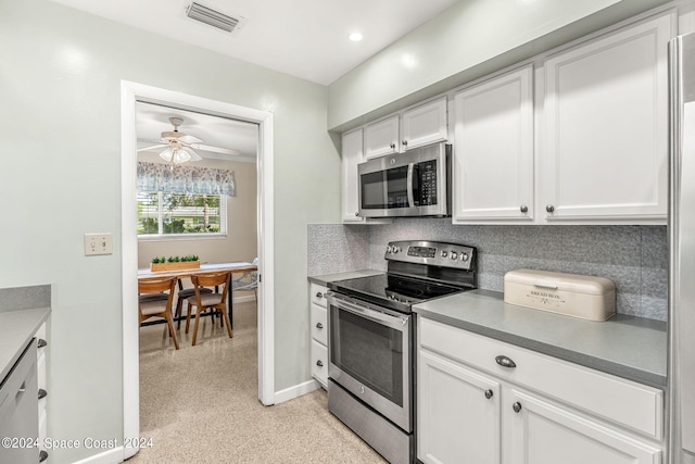 kitchen featuring appliances with stainless steel finishes, tasteful backsplash, ceiling fan, and white cabinets