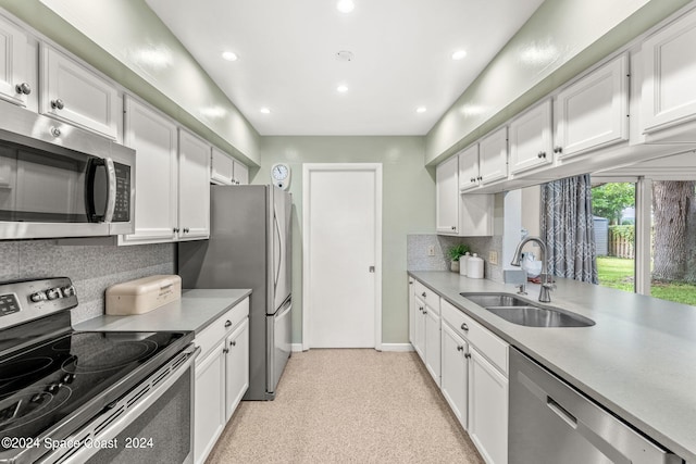 kitchen featuring white cabinets, backsplash, stainless steel appliances, and sink