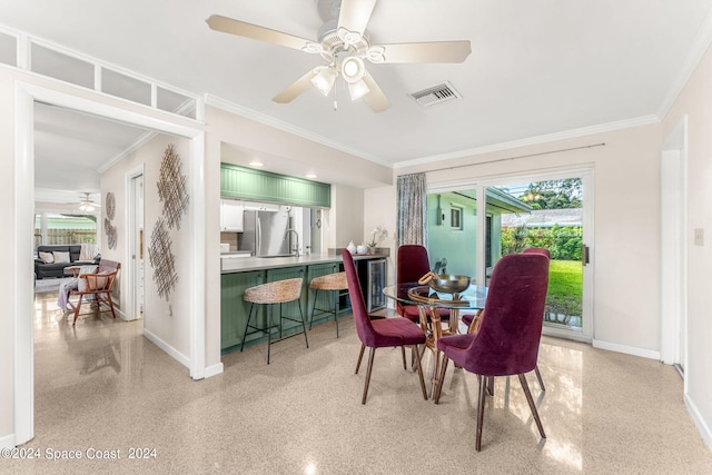 dining room featuring ceiling fan, ornamental molding, and sink