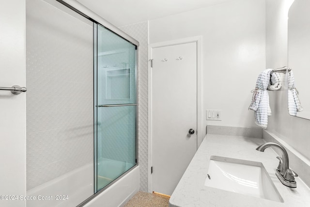 bathroom featuring vanity and bath / shower combo with glass door