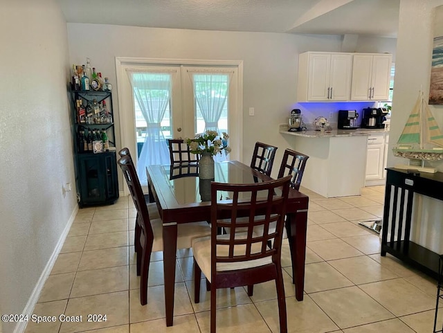 dining space with french doors and light tile patterned floors