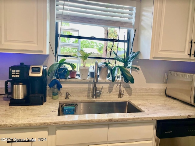 kitchen featuring sink, white cabinetry, light stone counters, and dishwasher