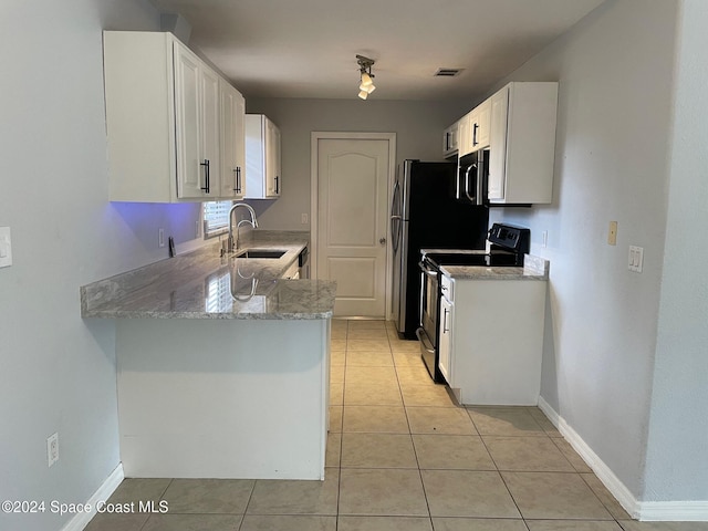 kitchen featuring appliances with stainless steel finishes, sink, white cabinets, light stone counters, and light tile patterned floors