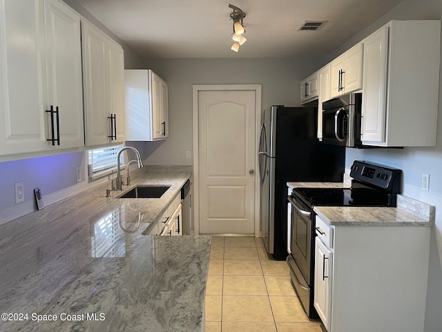 kitchen featuring appliances with stainless steel finishes, white cabinets, sink, and light tile patterned floors