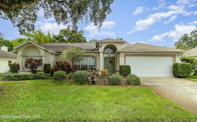 view of front of property with a front yard and a garage