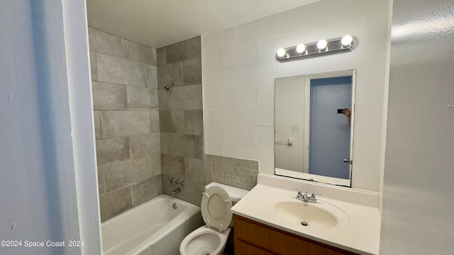 full bathroom with tiled shower / bath, vanity, and toilet