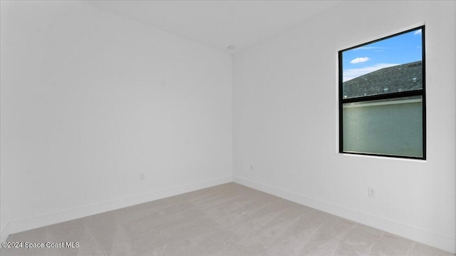 unfurnished room featuring light colored carpet