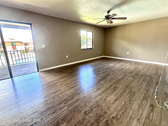 spare room with ceiling fan, dark hardwood / wood-style flooring, and a textured ceiling