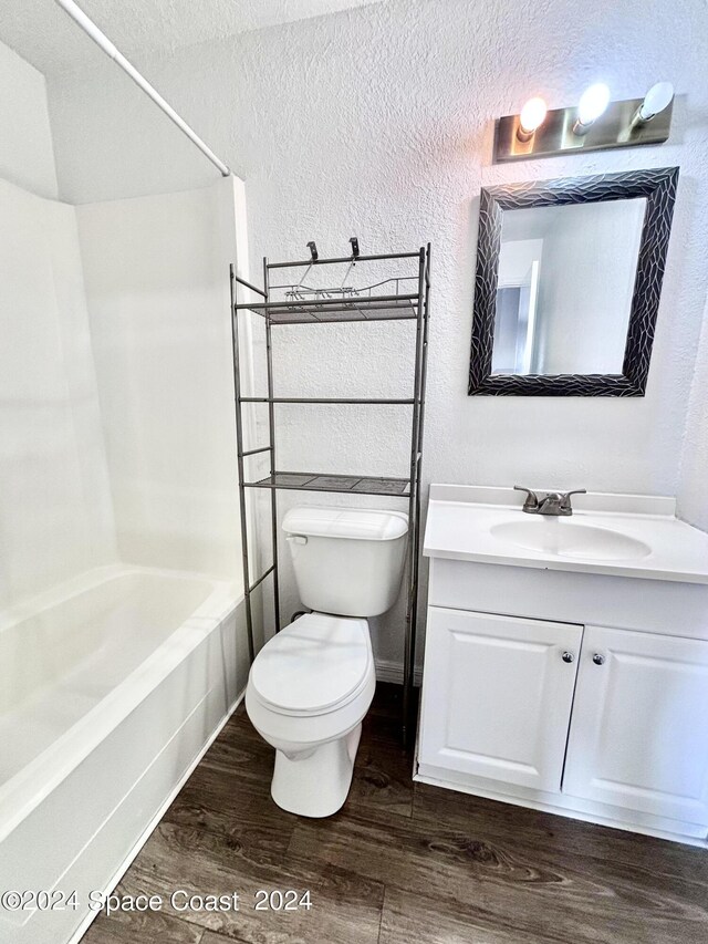 full bathroom with vanity, toilet, hardwood / wood-style floors, and  shower combination