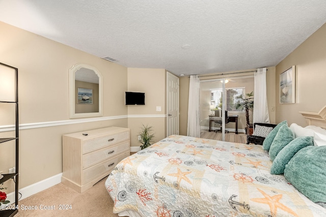 bedroom featuring light carpet and a textured ceiling