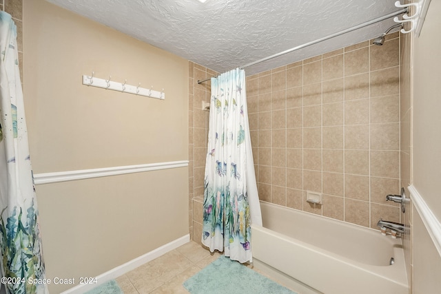 bathroom with a textured ceiling, shower / tub combo with curtain, and tile patterned flooring