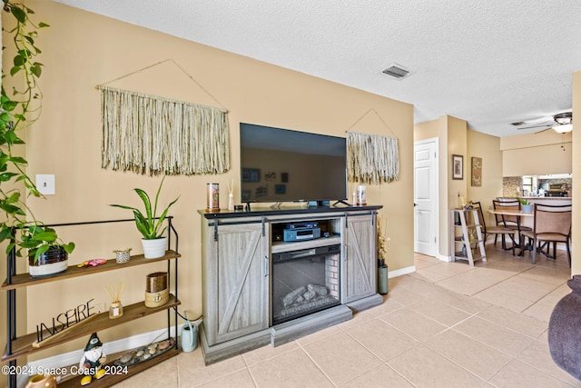 tiled living room with ceiling fan and a textured ceiling