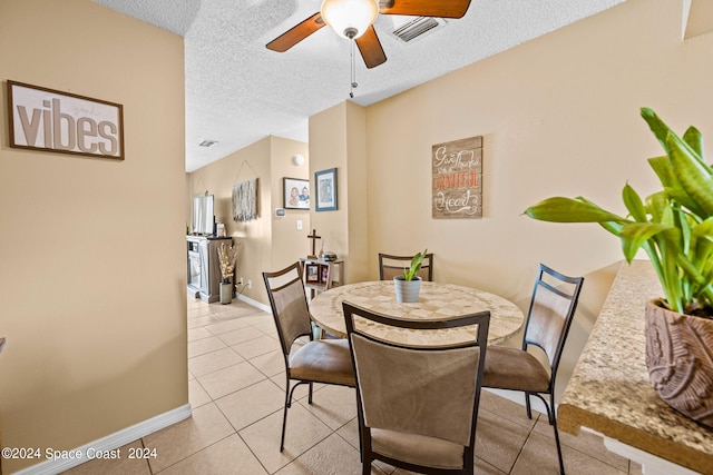 dining room with baseboards, light tile patterned floors, a textured ceiling, a ceiling fan, and visible vents