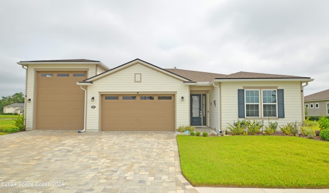 view of front of house with a garage and a front lawn