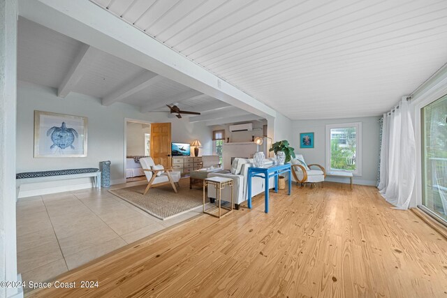 living room with ceiling fan, light hardwood / wood-style floors, a wall mounted air conditioner, and beam ceiling