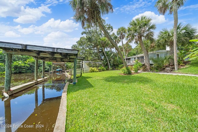 view of yard featuring a dock and a water view