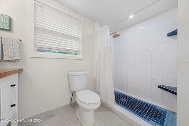 bathroom with vanity, toilet, a shower with shower curtain, and tile patterned floors