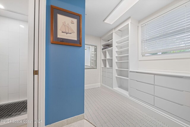 bathroom featuring tile patterned flooring and a tile shower