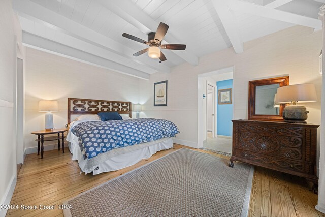 bedroom featuring light wood-type flooring, ceiling fan, and beam ceiling