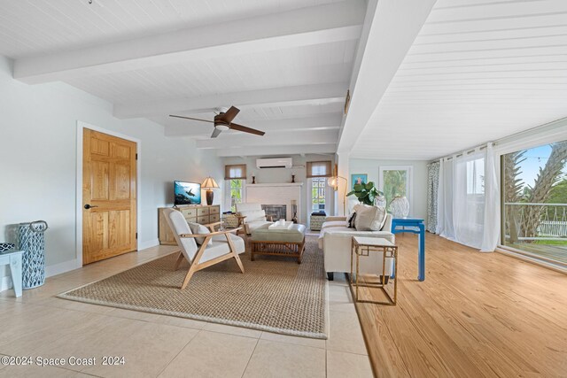 living room with beamed ceiling, an AC wall unit, light tile patterned floors, and ceiling fan