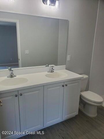 bathroom with vanity, hardwood / wood-style floors, and toilet