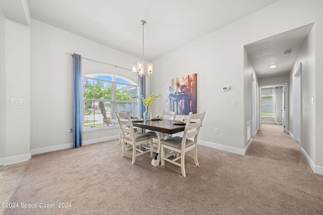 carpeted dining room with a textured ceiling and a notable chandelier