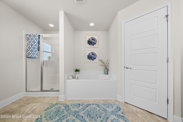 bathroom featuring a textured ceiling, tile patterned flooring, and shower with separate bathtub