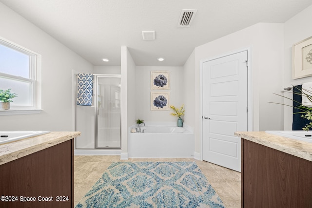 bathroom featuring vanity, independent shower and bath, and tile patterned floors